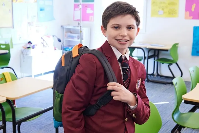 Smiling student in blazer with backpack